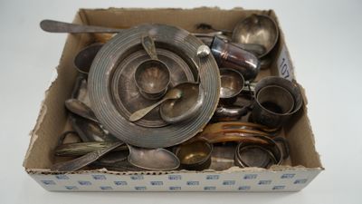 une boîte remplie de cuillères en argent et des cuillères posées sur une table