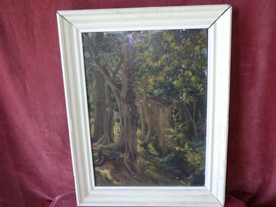 an oil painting of a forest scene in a white frame on a red cloth