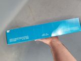 a person holding a box of toothpaste in their hand