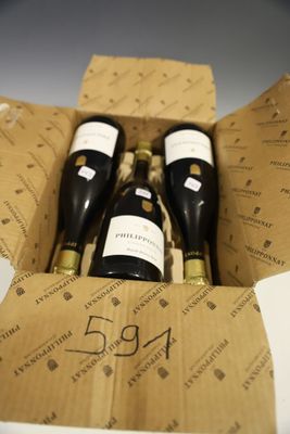 trois bouteilles de vin dans un carton sur une table