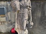 une statue représentant une femme tenant un panier à la main