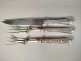 quatre fourchettes et un couteau sur une table blanche