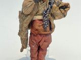 figurine représentant une femme portant un chapeau et une écharpe, tenant un téléphone portable