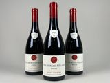 trois bouteilles de vin rouge posées sur une table