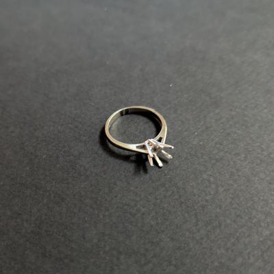 a close up of a silver ring on a black surface