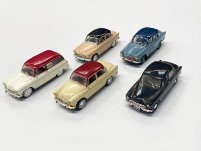 plusieurs petites voitures sont alignées sur une surface blanche