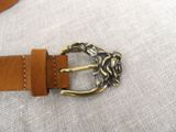 a brown belt with a brass buckle on it