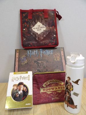 un livre de Harry Potter, une gourde et un livre posés sur une table