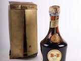 a bottle of liquor sitting next to a box on a table