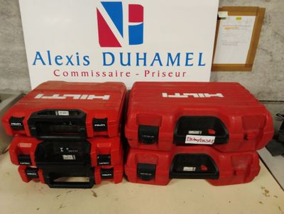 trois boîtes rouges munies de poignées noires sont posées à côté d'un panneau