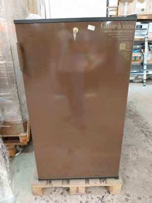 un réfrigérateur marron posé sur une palette dans un entrepôt
