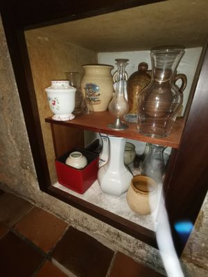 une étagère sur laquelle sont disposés de nombreux vases et tasses