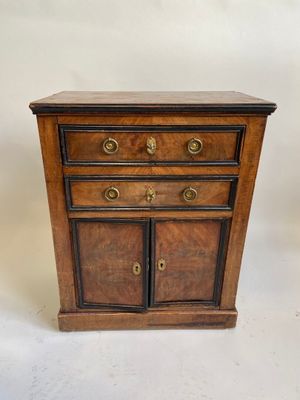 une petite commode en bois à deux portes et deux tiroirs