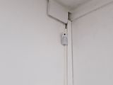 a white air conditioner on the wall in the corner of a room