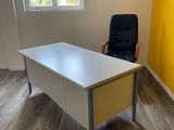 un bureau avec une chaise et une fenêtre dans la pièce