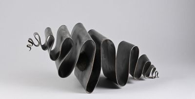 sculpture made of black metal spirals on a white surface