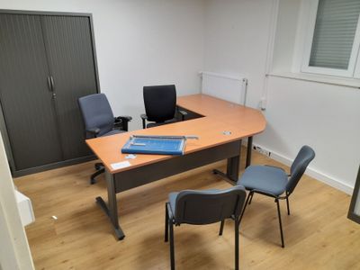 an image of an empty office with a desk and chairs