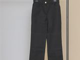 a black pants hanging on a rack in front of a wall
