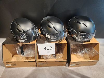 three helmets are sitting in boxes on a table with a price tag