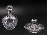 une paire de flacons de parfum en cristal taillé posés sur une surface noire