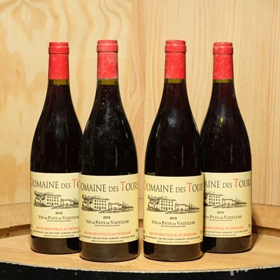 three bottles of wine are lined up on a wooden barrel
