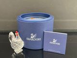 un bac bleu avec une figurine de cygne blanc à côté