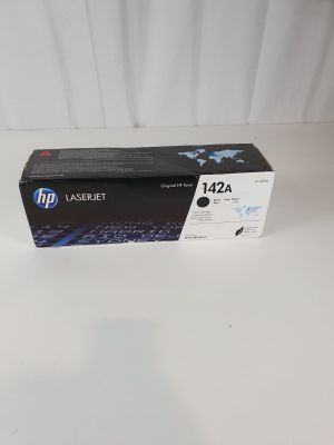une cartouche de toner HP 124a noire posée sur une surface blanche