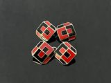 four red and black squares on a black surface