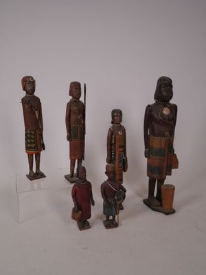 plusieurs figurines en bois de formes et de tailles variées posées sur une surface blanche