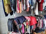 a lot of clothes hanging on a rack in a room