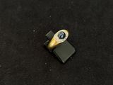 une bague en or sertie d'une pierre bleue posée sur un téléphone portable
