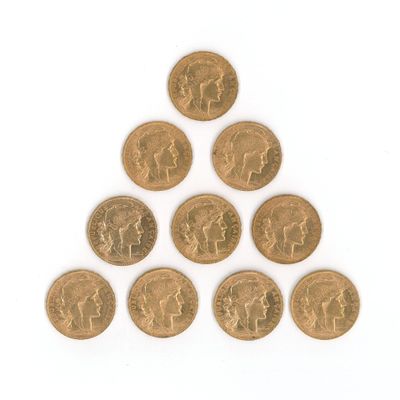un gros plan d'un triangle formé de pièces de monnaie posées sur une surface blanche