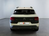 the rear of a white and black car in a white room