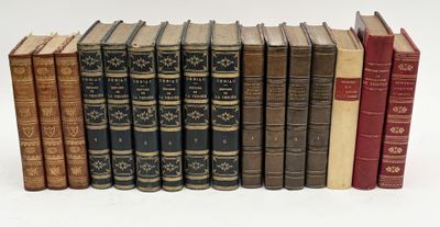 several old books are lined up in a row on a white surface