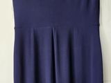 navy blue sleeveless dress on hanger against white wall