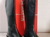 Les bottes noires se trouvent à côté d'une boîte rouge sur la table.