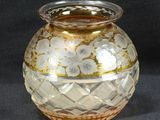 un vase en verre orné d'un motif doré et blanc