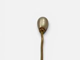 a close up of a brass hook on a white wall