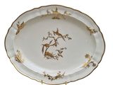 an oval platter decorated with birds and flowers on a white background