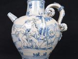 a blue and white vase with a handle on a black background