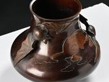 a brown vase sitting on top of a white table