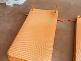 two orange beds sitting on the floor next to each other