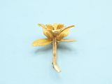 gold plated flower brooch on a blue background