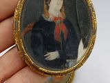 a miniature picture of a woman in a black dress and a miniature picture of a man in a red hat