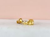 a pair of gold earrings on a marble surface