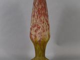 a red and yellow vase sitting on a white table