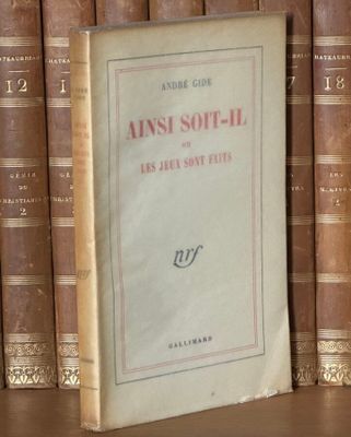 un vieux livre posé sur une étagère, devant une pile de livres