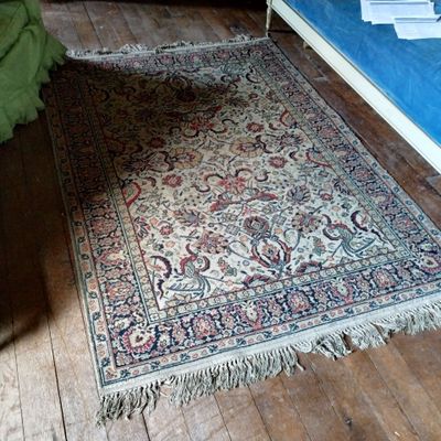 un tapis posé à même le sol dans une chambre où se trouve un lit