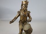 figurine en laiton représentant un soldat tenant un tambour, posée sur un socle
