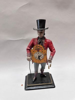 a figurine of a man in a top hat holding a clock